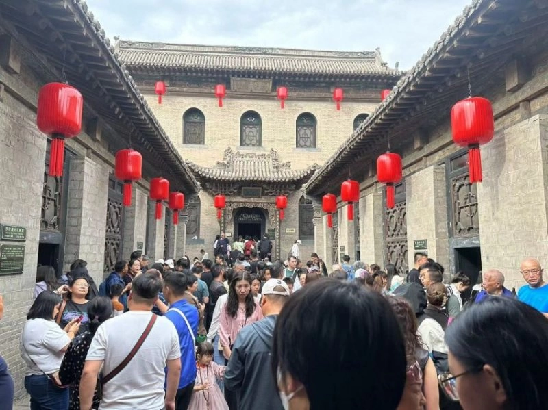 假日的乔家大院游人如织、秩序井然,迎来客流高峰